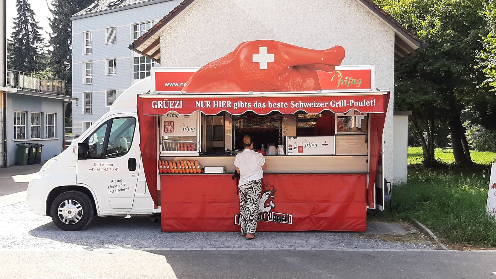 Eine Frau steht vor einem Foodtruck.